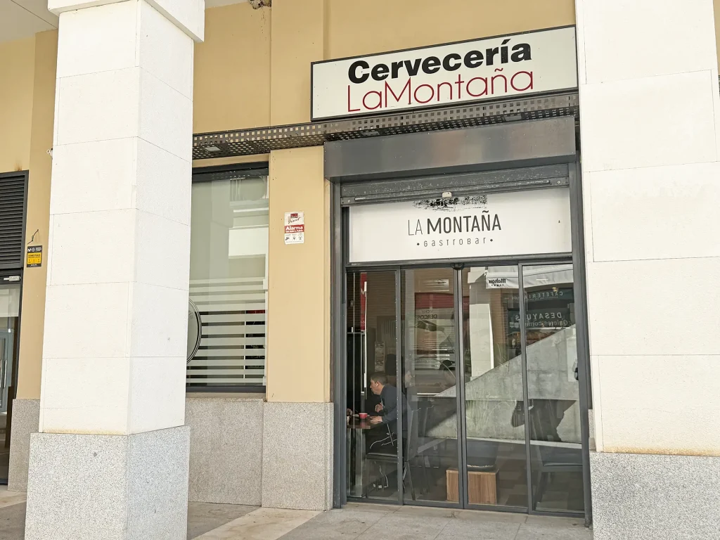 Vista exterior del Restaurante La Montaña con mesas al aire libre y entrada secundaria al establecimiento